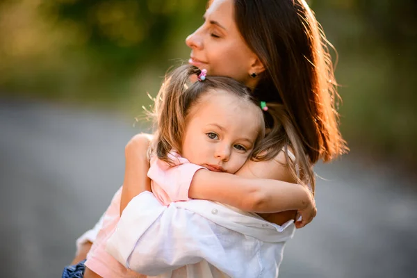 Portret van vrouw die kleine dochter in de armen houdt en knuffelt haar — Stockfoto