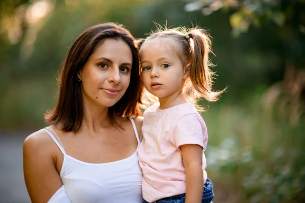 Vue rapprochée de la femme qui tient dans ses bras une petite fille blonde — Photo