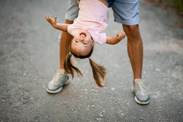 Glückliches Mädchen, das ihr Vater auf den Kopf stellt und — Stockfoto