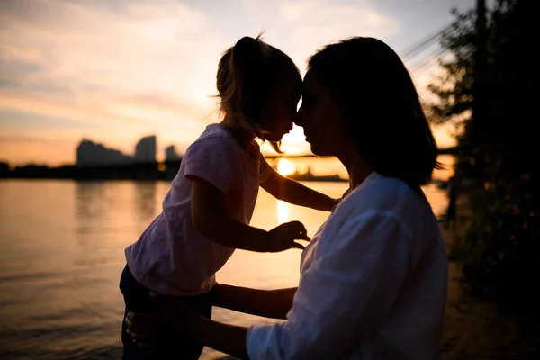 Vue latérale sur les silhouettes de la mère et de la petite fille se regardant — Photo