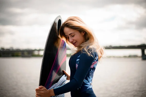 Belle femme avec les yeux fermés tient la planche de surf et repose la tête dessus — Photo