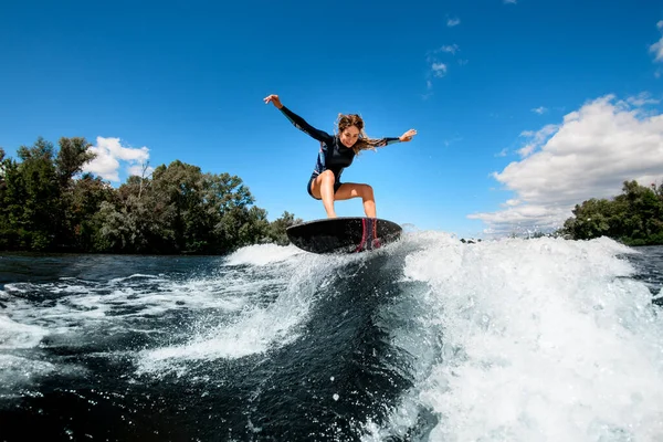 Femme active équilibrage frileux sur planche de surf sur vague éclaboussante — Photo