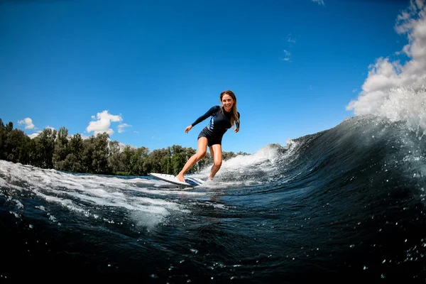 陽気可愛いです若いです女性で水着でザ波ダウンザ · サーフボード — ストック写真