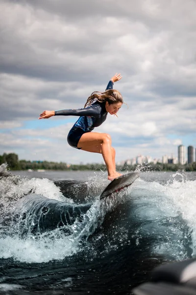 若いスポーツ女性はサーフボードの波に効果的に飛び乗って — ストック写真