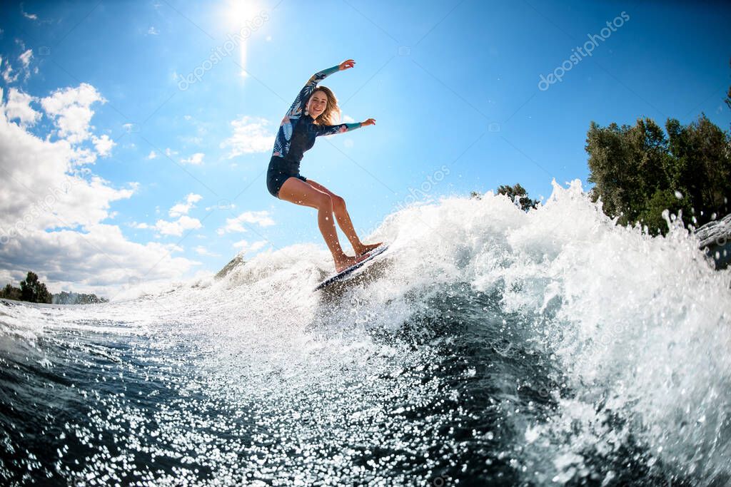 happy young woman actively ride surfboard on the wave