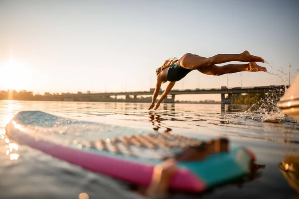 Красивая спортсменка в купальнике прыгает в воду. — стоковое фото