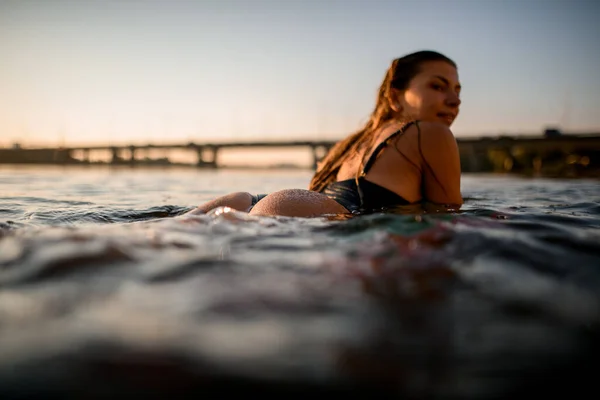 Γκρο πλαϊνή άποψη της γυναίκας που βρίσκεται στο στυλ surf wakeboard στο νερό — Φωτογραφία Αρχείου