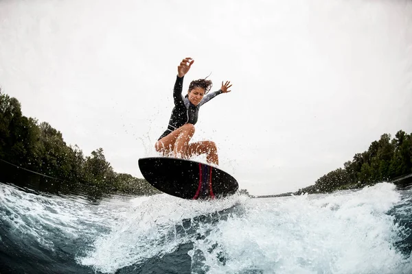 Sportliche Frau springt meisterhaft auf die Welle — Stockfoto