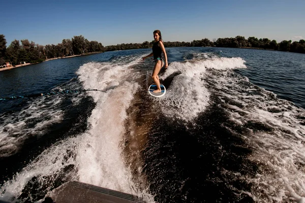 Vue grand angle de la jeune femme wakesurfer monte la vague du bateau — Photo