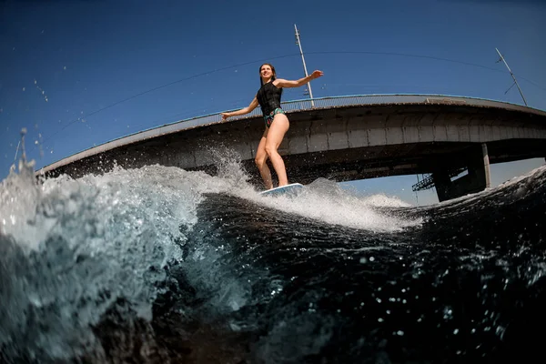 Attraktive Wakeboard-Fahrerin sorgt für viele Spritzer am Fluss — Stockfoto