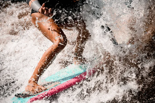 Close-up of tanned legs of sporty woman who actively riding on surf style wakeboard. — Stock Photo, Image