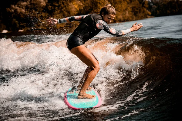 Jeune femme énergique aller dans le sport nautique actif avec surf style wakeboard — Photo
