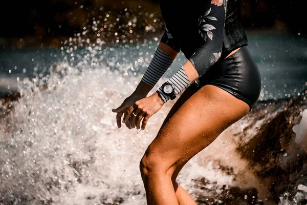 Крупним планом жіноче тіло в гідрокостюмі активно їздить на хвилі — стокове фото