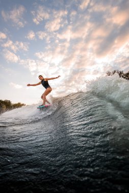Sörf stili Wakeboard 'a binen yakışıklı bir kadın.