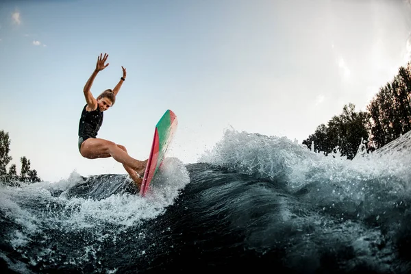 Mulher tentar equilibrar no wakeboard estilo surf na onda do rio salpicado — Fotografia de Stock