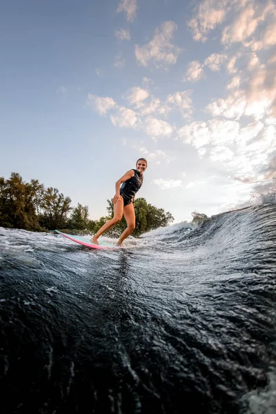 Sörf stili Wakeboard 'a binen güzel genç bir kadın.