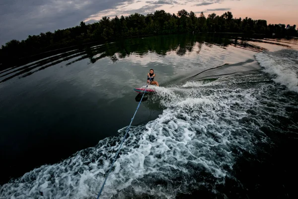 Visão de alto ângulo da mulher no estilo surf wakeboard segurando corda e passeios na água — Fotografia de Stock