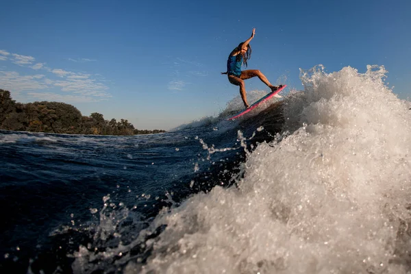 Bela mulher esportiva pulando em grande onda salpicando no wakeboard estilo surf. — Fotografia de Stock