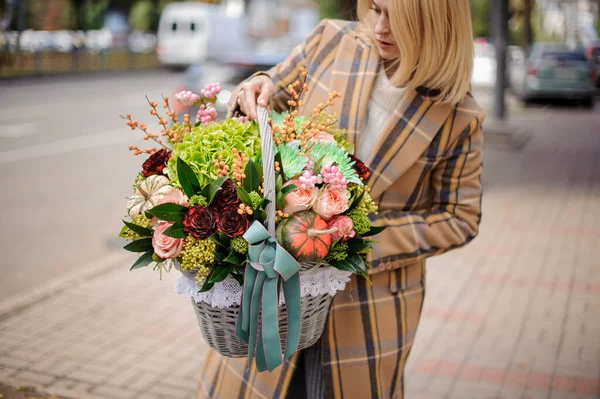 Primer plano de cestas de mimbre con varias flores y bayas en las manos de las mujeres — Foto de Stock