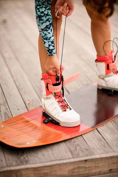 Vista close-up em pernas femininas atléticas fixadas em botas de wakeboarding board — Fotografia de Stock