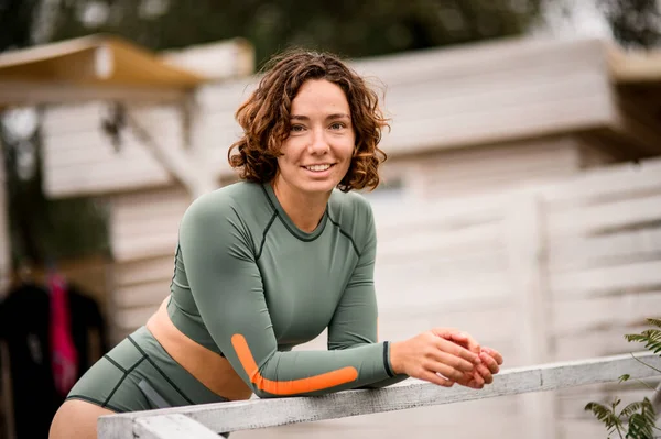 Jeune femme souriante aux cheveux bouclés en maillot de bain en nylon — Photo