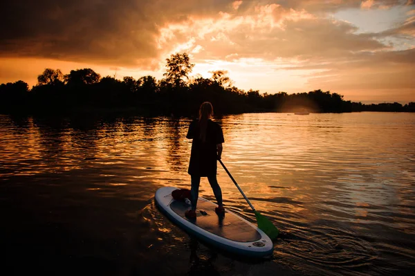 Zadní pohled mladé ženy na sup palubě plovoucí na řece — Stock fotografie