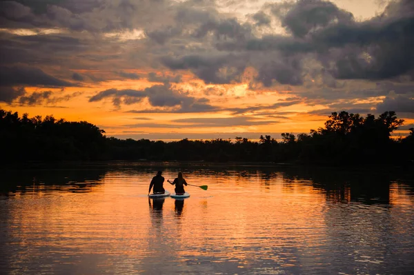 Hermosa vista en pareja flotando en tablas de sup en el río —  Fotos de Stock