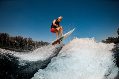 Dalgaların üzerinden atlayan sörf stili Wakeboard 'un üzerindeki atletik adam görüntüsü