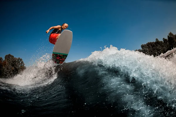 Energético desportivo homem pulando na onda no wakeboard estilo surf — Fotografia de Stock