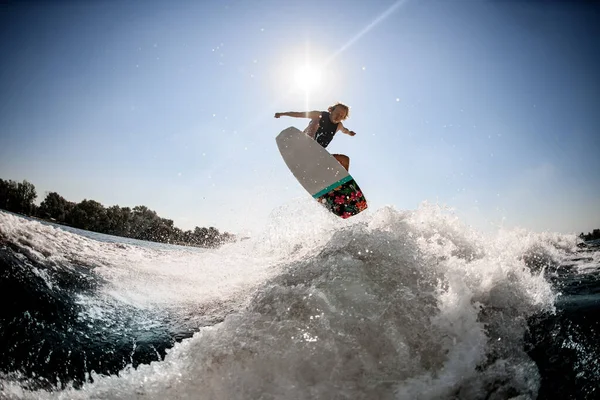 Vista del hombre en el wakeboard estilo surf saltando magistralmente sobre la ola salpicadura —  Fotos de Stock
