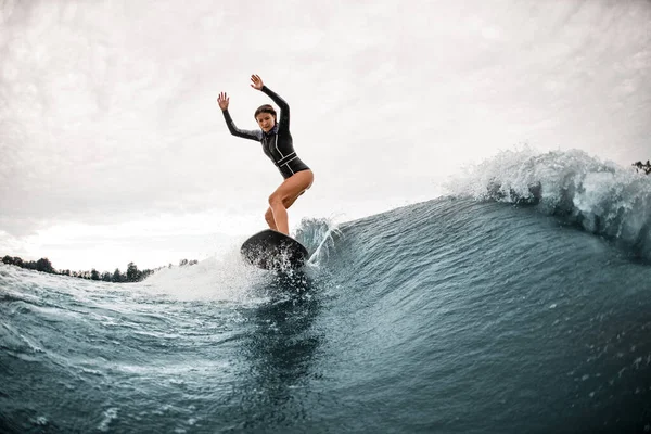 若い女性がサーフボードに立ち波に積極的に乗り — ストック写真