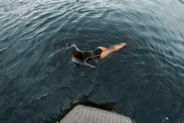 Hochwinkelaufnahme einer Frau, die aktiv auf dem Wasser schwimmt — Stockfoto