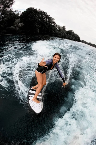 サーフボードに乗って明るい女性の高い角度ビューとカメラを見て — ストック写真