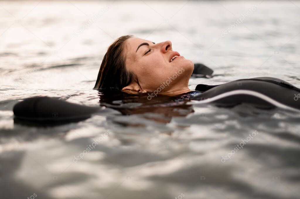 close-up of handsome young woman in black swimsuit with closed eyes
