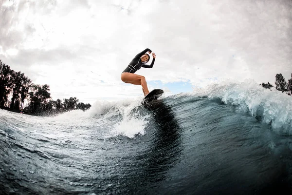 Happy smiling woman riding the wave on surfboard on warm summer day — Stock Photo, Image