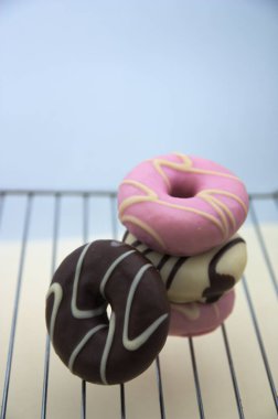 Farklı renkte ve aromalı tatlı çörekler. Izgarada koyu ve beyaz çikolata ve fotokopi alanı var.