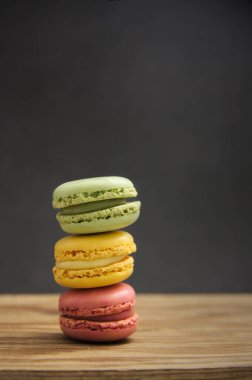 Koyu arkaplan, yan ışık ve kopyalama alanı olan ahşap bir masa üzerinde farklı tat ve renklerden oluşan bir yığın.