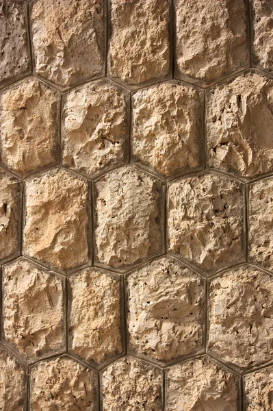 Altıgen bir desenle dekore edilmiş duvar doğal bir şekilde sıralı taşları taklit ediyor.