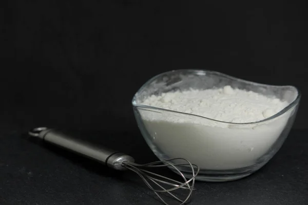 Close Glass Bowl White Flour Next Silver Whisk Dark Background — Stock Photo, Image