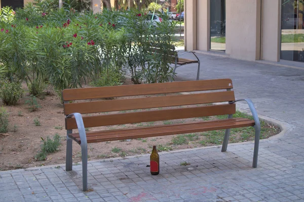 在城市公园的长椅上 有人把空啤酒瓶留在那里 — 图库照片
