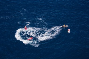 Dört sürat teknesi yazın deniz kenarında eğleniyor.