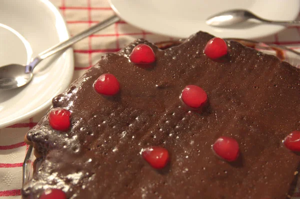 Üstü Çikolata Kırmızı Kirazla Süslenmiş Bisküvi Kekinin Kapağı Masada Servis — Stok fotoğraf