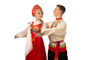 Beautiful caucasian cuple dancing in Russian folk costumes isolated on white background