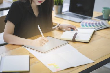 Genç Asya grafik tasarımcı onu çalışma alanında bilgi işlem ve grafik tablet üzerinde çalışıyor