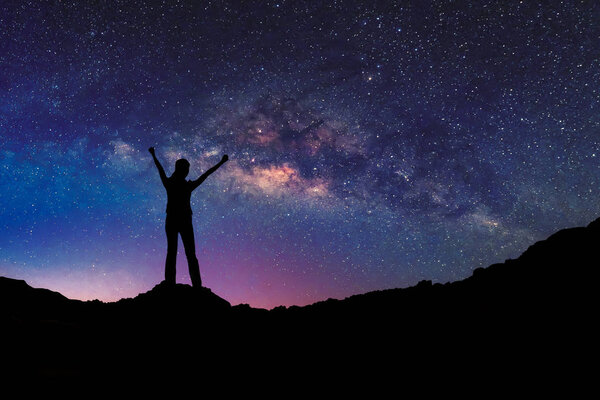 Счастливая свободная женщина на горе со звёздным ночным небом. свобода и концепция победы
.