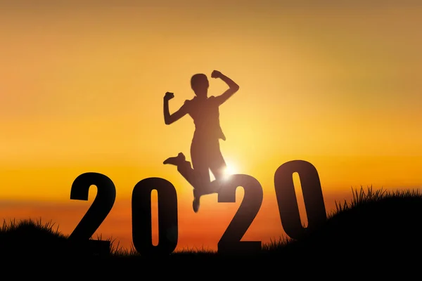 2020 mutlu yeni yıl ile tepeye atlama genç kadın silueti. 