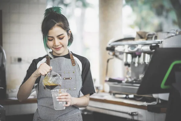 Asya sevimli barista kahve dükkanında kahve yapma