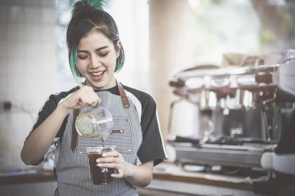 Asya sevimli barista kahve dükkanında kahve yapma