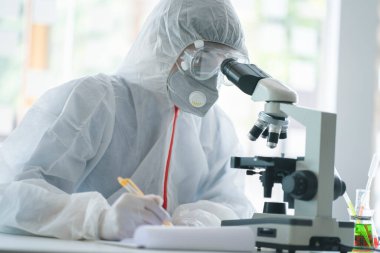 Medical scientist analyzing microscope slides in research lab for 2019-nCoV vaccine or serum.