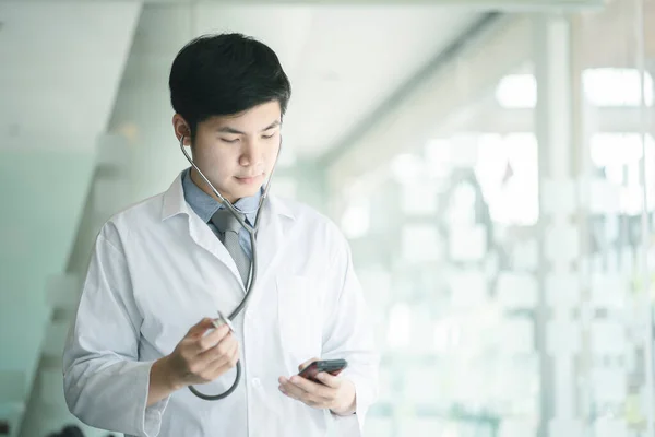 Health care and medical services concept. Close up of Medical doctor with a stethoscope and mobile phone in the hands.